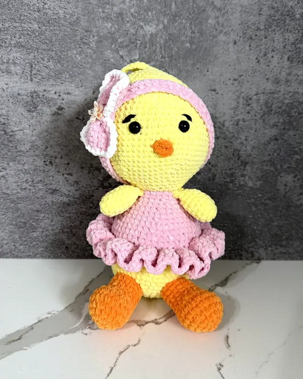 Yellow crochet chick in a pink ruffled dress